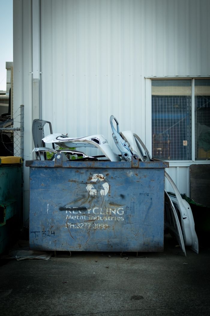 A metal recycling bin with car parts outside a building in Brisbane, Australia.